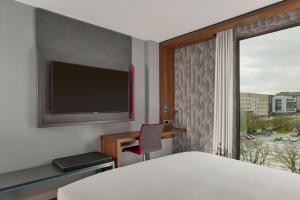 伯明翰Aloft Birmingham Eastside的一间卧室设有一张床和一个带电视的窗户。