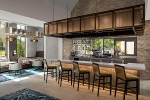 杰克逊维尔Residence Inn By Marriott Jacksonville-Mayo Clinic Area的厨房设有酒吧、椅子和桌子