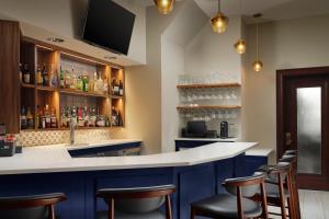 波士顿Marriott Vacation Club® at Custom House, Boston  的一间酒吧,配有蓝色橱柜和酒吧凳子