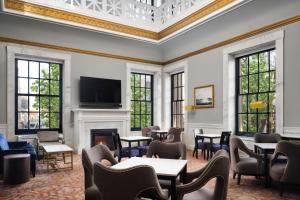 波士顿Marriott Vacation Club® at Custom House, Boston  的一间设有桌椅和壁炉的等候室