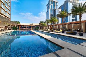 班加罗尔JW班加罗尔万豪酒店的一座棕榈树和建筑游泳池