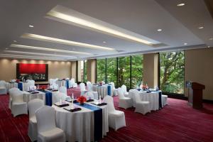 班加罗尔JW班加罗尔万豪酒店的宴会厅配有白色的桌子和白色的椅子
