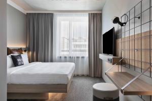 不莱梅Moxy Bremen的酒店客房设有床和窗户。