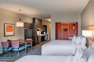 奥斯汀TownePlace Suites Austin South的酒店客房带一张床、一张桌子和椅子