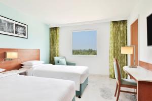 班加罗尔Fairfield by Marriott Bengaluru Whitefield的酒店客房配有两张床和一张书桌