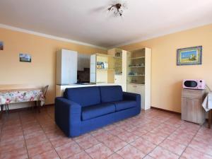 卡尼洛瑞维拉Appartamento Porto 1的一间带蓝色沙发的客厅和一间厨房