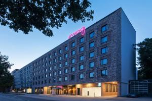 汉堡Moxy Hamburg City的上面有粉红色标志的酒店大楼