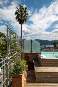 圣玛格丽塔-利古雷密涅瓦酒店的一个带游泳池和棕榈树的阳台