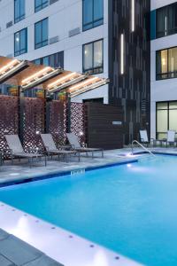休斯顿Courtyard by Marriott Houston Heights/I-10的一座带躺椅的游泳池位于大楼旁