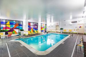 塔尔萨Fairfield Inn & Suites Tulsa Downtown Arts District的游泳池位于酒店客房内,墙壁上装饰着色彩缤纷的艺术作品