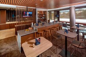 纽瓦克Springhill Suites By Marriott Newark Downtown的餐厅设有酒吧,配有凳子和桌子