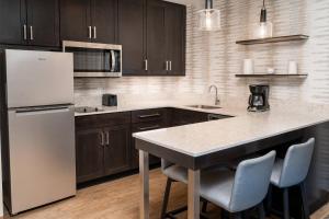大急流城Residence Inn by Marriott Grand Rapids Downtown的厨房配有棕色橱柜和白色冰箱
