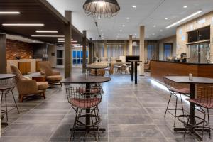 印第安纳波利斯Courtyard by Marriott Indianapolis West-Speedway的大堂设有桌椅和酒吧。