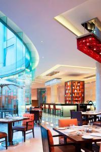 尼杜巴塞莱高知机场万怡酒店的餐厅设有桌椅和大型玻璃墙