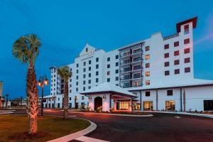 纳瓦拉纳瓦拉海滩万豪春季山丘套房酒店 的一间大型的白色酒店,前面有一棵棕榈树