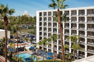 安纳海姆Fairfield by Marriott Anaheim Resort的公寓大楼设有游泳池和棕榈树