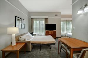摩根敦Residence Inn by Marriott Morgantown Medical Center Area的酒店客房配有床、沙发和电视。