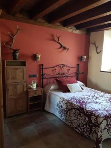 La Cabaña的一间卧室设有一张床和红色的墙壁