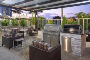 肯代尔TownePlace Suites Miami Kendall West的户外庭院设有烧烤架、桌椅
