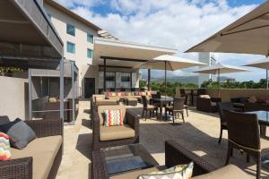 金斯敦牙买加金斯顿万怡酒店的一个带桌椅和遮阳伞的户外庭院。