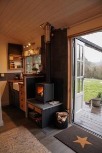 布里斯托Shepherds Hut in countryside near Bath and Bristol的厨房设有一扇门,可通往带炉灶的厨房
