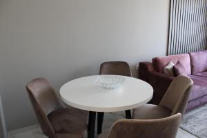 帕莫瑞Inter Holiday Apartments的一间配备有白色桌椅的用餐室