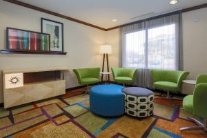 拉斯维加斯Fairfield by Marriott Inn & Suites Las Vegas Stadium Area的一间设有绿色椅子和桌子的等候室