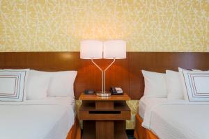 拉斯维加斯Fairfield by Marriott Inn & Suites Las Vegas Stadium Area的酒店客房设有两张床和床头灯。