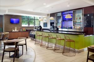 奥兰多万豪奥兰多海洋世界春山套房酒店的餐厅设有绿色酒吧,配有桌椅