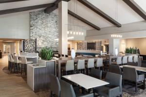 奥兰多奥兰多海洋世界万豪原住客栈的一间带桌椅和石墙的餐厅