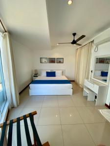 亭可马里Beach Paradise Nilaveli的一间白色卧室,配有床和天花板