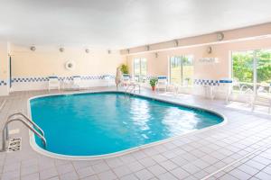 米德尔敦米德尔敦门罗费尔菲尔德客栈的酒店客房的大型游泳池配有椅子和桌子