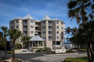 斯图尔特Marriott Hutchinson Island Beach Resort, Golf & Marina的一座大型公寓楼,拥有棕榈树和凉亭