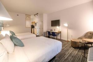 孔洛TownePlace Suites by Marriott Conroe的酒店客房,配有一张床、一张桌子和椅子