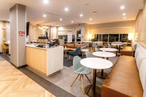 孔洛TownePlace Suites by Marriott Conroe的一间带桌椅的餐厅和一间酒吧