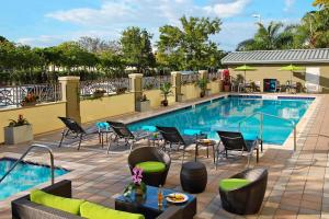 达尼亚滩劳德代尔堡机场/邮轮港口万豪费尔菲得酒店的一个带椅子和桌子的酒店游泳池