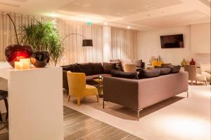 勒布尔热AC Hotel by Marriott Paris Le Bourget Airport的客厅配有沙发和椅子