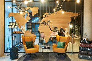 鲁瓦西昂法兰西Moxy Paris Charles de Gaulle Airport的一张带两把椅子的墙上的木制世界地图