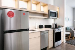 麦迪逊TownePlace Suites by Marriott Madison West, Middleton的厨房配有不锈钢冰箱和微波炉。