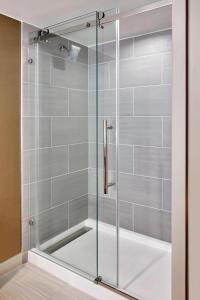 凤凰城Marriott Phoenix Airport的浴室设有玻璃门淋浴