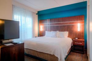 罗利万豪罗利瑰珀翠谷原住酒店的配有一张床和一台平面电视的酒店客房
