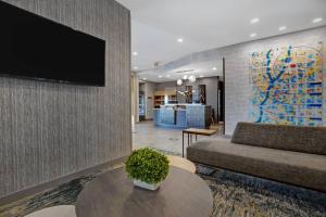 格伦代尔TownePlace Suites by Marriott Phoenix Glendale Sports & Entertainment District的客厅配有沙发和墙上的电视