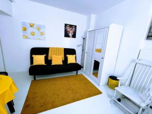 莫尔科泰Ca' Sistina Yellow的客厅配有黑色沙发和椅子