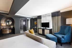塔尔萨塔尔萨品牌吉臣酒店的酒店客房设有床和客厅。