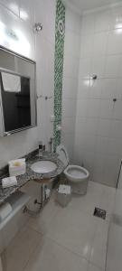 阿瓜斯迪林多亚Flat Cavalinho Branco - 50J的一间带水槽、卫生间和镜子的浴室