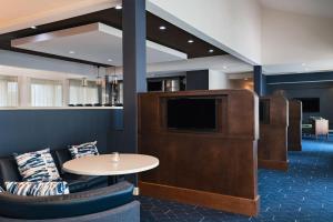 圣安东尼奥万怡酒店圣安东尼奥机场的一间配有电视和桌椅的等候室