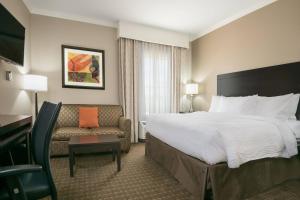 塞金塞甘万豪唐普雷斯套房酒店的酒店客房设有一张大床和一张沙发。