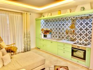 都拉斯Beach Garden Paradise的厨房配有绿色橱柜和沙发