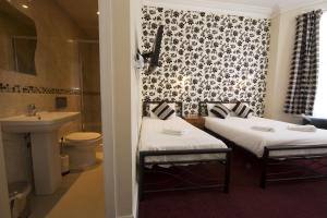伦敦伦敦皇家萨巴酒店的配有2张床的带水槽和浴室的客房