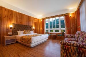 拉亨Summit Gangchen Hotel的一间卧室配有一张床和一张沙发